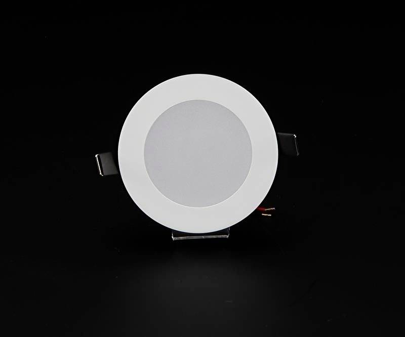 Ein runder, weißer LED-Einbaustrahler mit schwarzem Hintergrund. Der Strahler hat zwei seitliche Befestigungsclips.