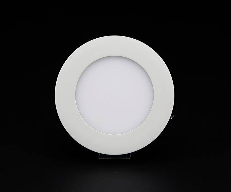 Runde, weiße Deckenleuchte vor schwarzem Hintergrund. Sie hat ein minimalistisches Design und wird von einem dünnen Ring gefasst.