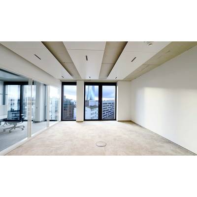 Leerer Büroraum mit Teppichboden, großen Fenstern und Stadtblick. Glaswände trennen einen Besprechungsbereich.