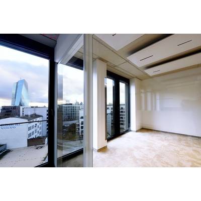 Leeres, modernes Büro mit großen Fenstern, Blick auf die Skyline einer Stadt mit einem markanten Hochhaus im Hintergrund.