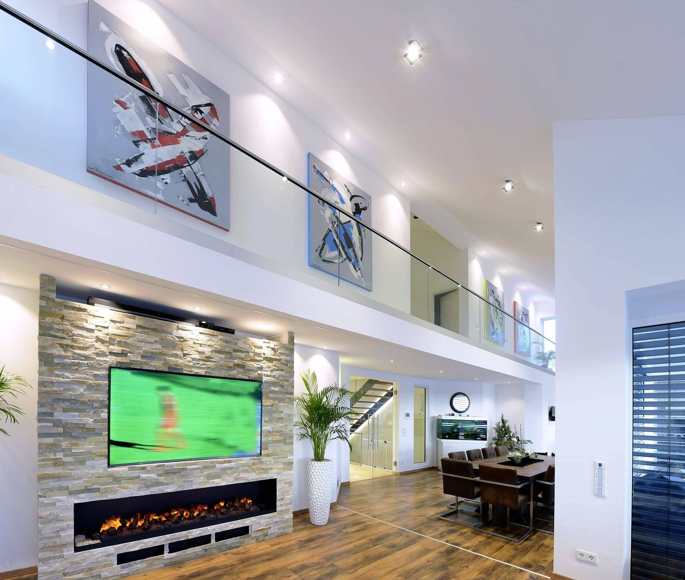 Modernes Wohnzimmer mit zweistöckigem Loft, Wandkunst, Kamin, großem TV und Esstisch; stilvoll eingerichtet mit Holzfußboden.