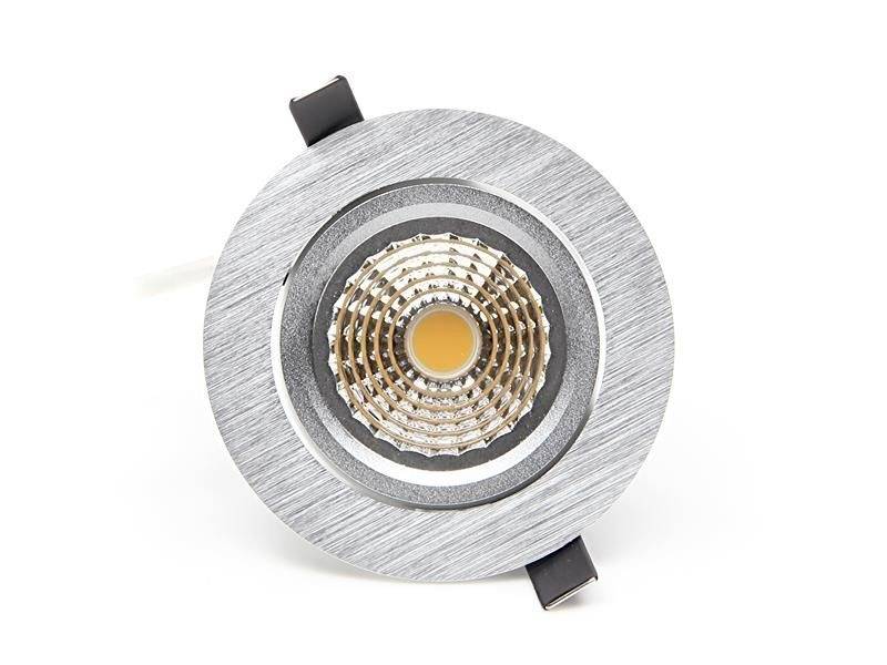 Ein runder LED-Einbaustrahler mit silbernem Rahmen und wabenförmigem Reflektor in der Mitte, geeignet für Deckenbeleuchtung.
