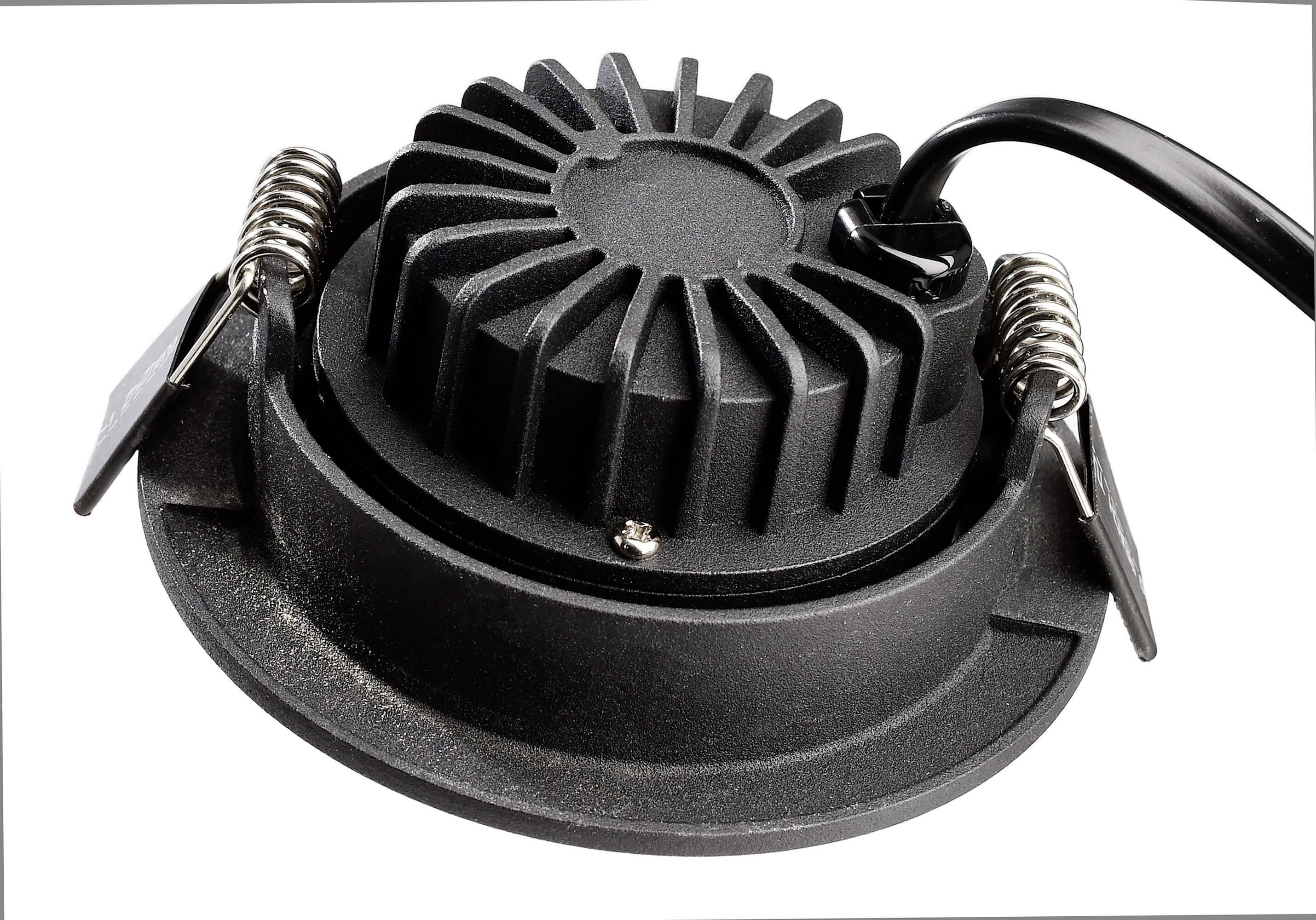 Ein schwarzes, rundes LED-Downlight mit Kühlrippen und Federclips für die Deckenmontage, Kabel an der Seite angeschlossen.