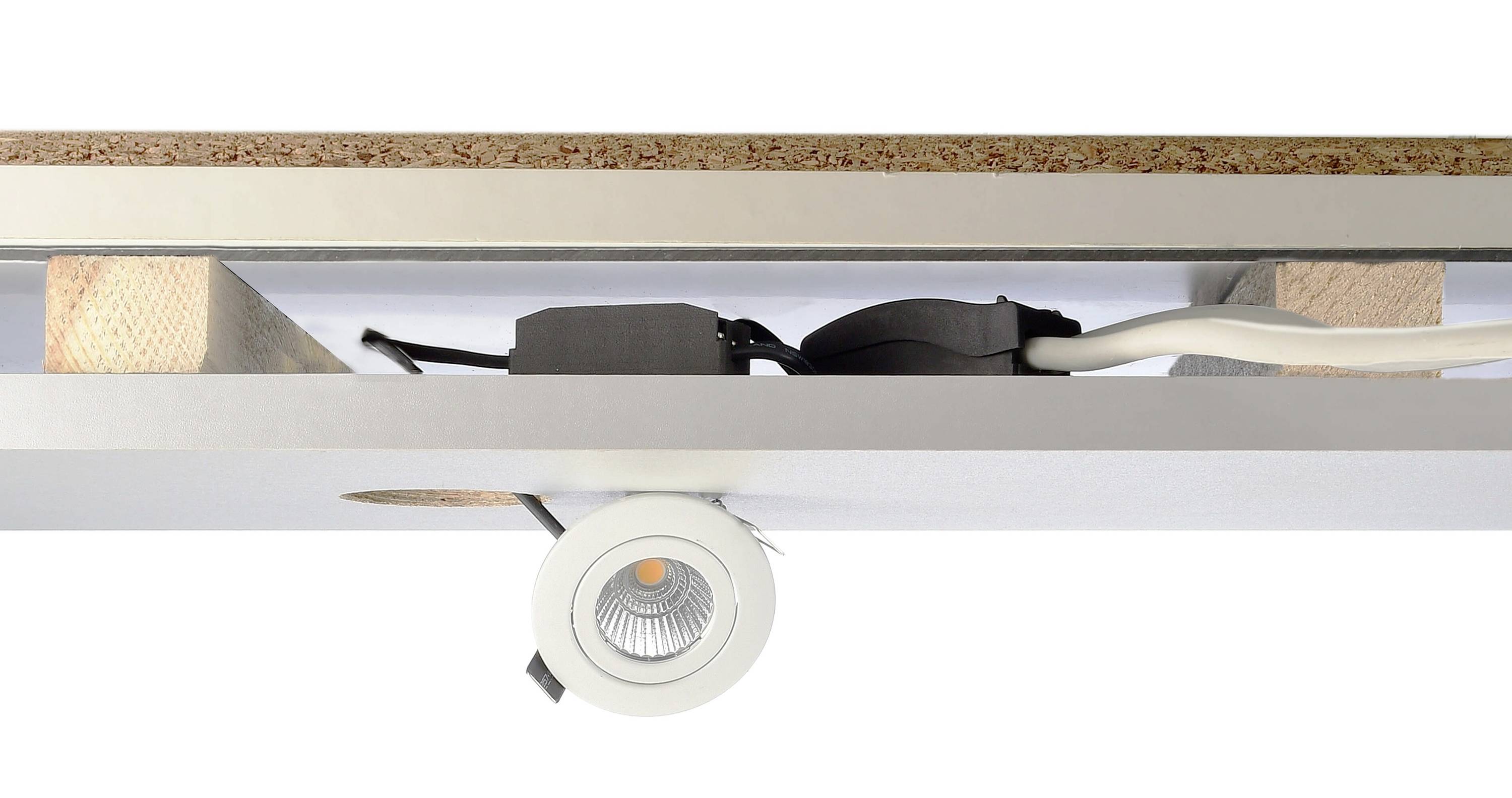 Einbau-Spotlight, montiert in einer Decke aus Holz und Gipskarton. Elektrische Verkabelung und Befestigungselemente sind sichtbar.