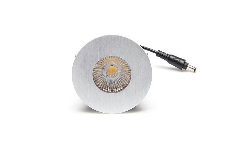 'Runde, silberne LED-Lampe mit zentraler Lichtquelle und schwarzem Kabel auf weißem Hintergrund.'