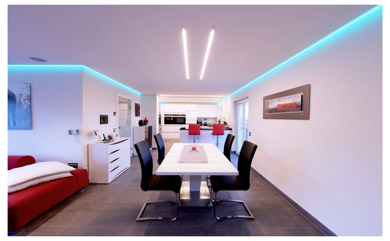 Modernes Esszimmer mit einem langen weißen Tisch, schwarzen Stühlen, roten Sitzbänken und blauen LED-Deckenleuchten in einem hellen, offenen Wohnbereich.