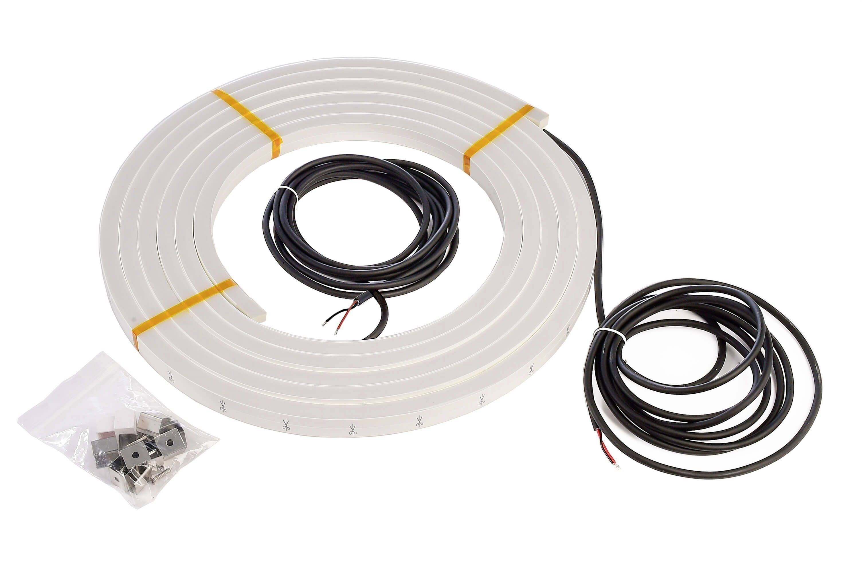 Langes, weißes LED-Lichtband aufgerollt mit zwei schwarzen Kabeln und Schraubzubehör in einem Beutel daneben.