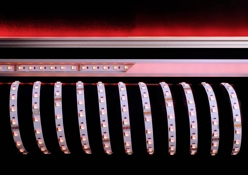 LED-Streifen mit leuchtenden Dioden in einer dunklen Umgebung, Hintergrund in Rot beleuchtet.