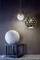 Drei moderne Lampen mit geometrischen Mustern: zwei hängen an der Decke, eine steht auf einem Tisch. Sie beleuchten einen Raum stilvoll.