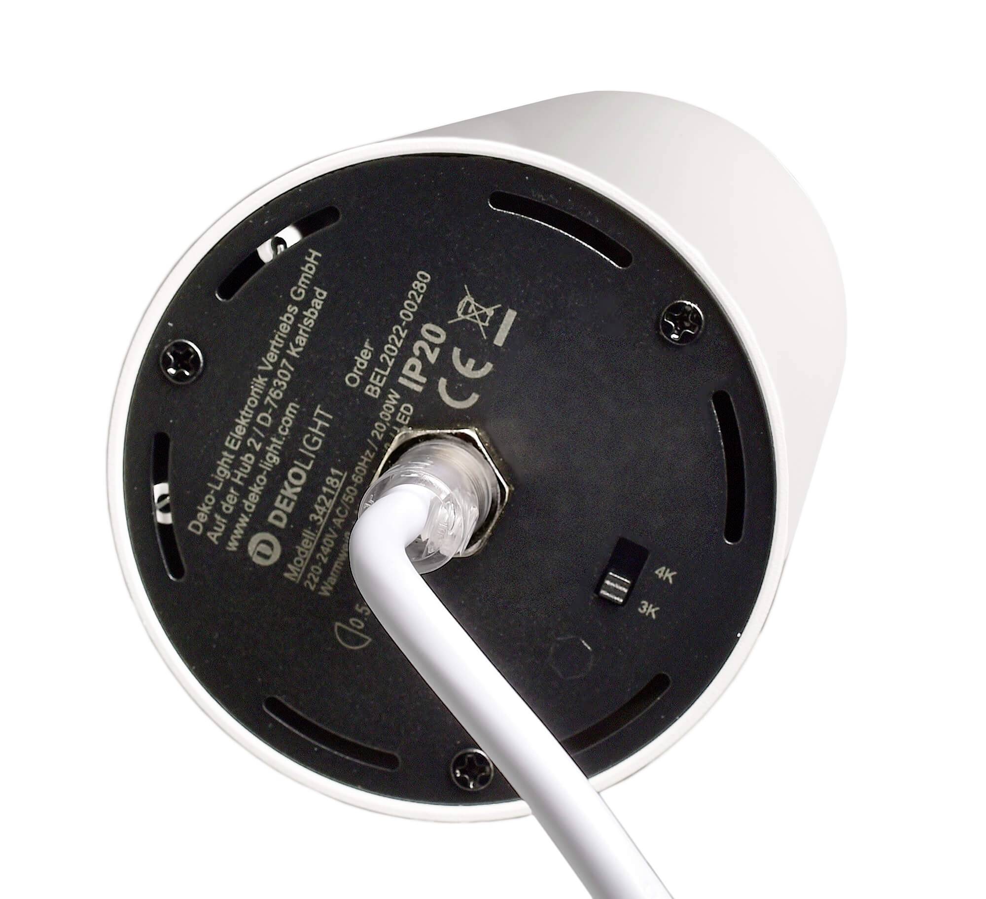 Unterseite einer elektrischen Komponente mit weißem Kabel. Auf dem schwarzen Boden sind technische Daten und Seriennummer aufgedruckt.