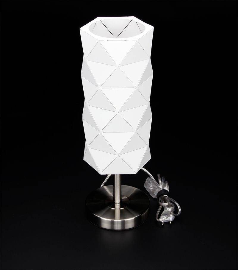 Weiße, geometrische Tischlampe auf schwarzem Hintergrund, mit einem Satz Schlüssel links daneben.