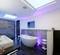 Modernes Badezimmer mit freistehender Badewanne, großer Dusche und stimmungsvoller LED-Beleuchtung in blauen und violetten Tönen.
