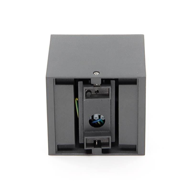 Ein schwarzes, rechteckiges Bauteil mit zentralem Halterungsmechanismus und sichtbaren, farbigen Kabeln im Inneren.