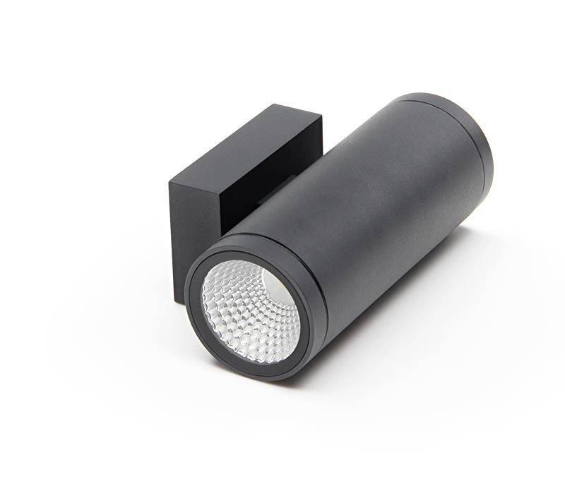 Ein schwarzer zylindrischer Wandstrahler mit rechteckiger Halterung, nach rechts zeigend. Für Innenbeleuchtung geeignet.