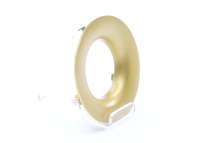 Ein goldener, ringförmiger Gegenstand auf einem transparenten Ständer, vor einem weißen Hintergrund.