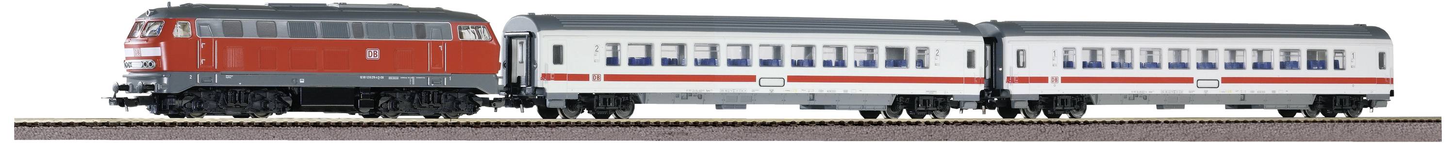 Ein Modellzug mit einer roten Lokomotive und zwei weißen Passagierwaggons bewegt sich auf einem Gleis.