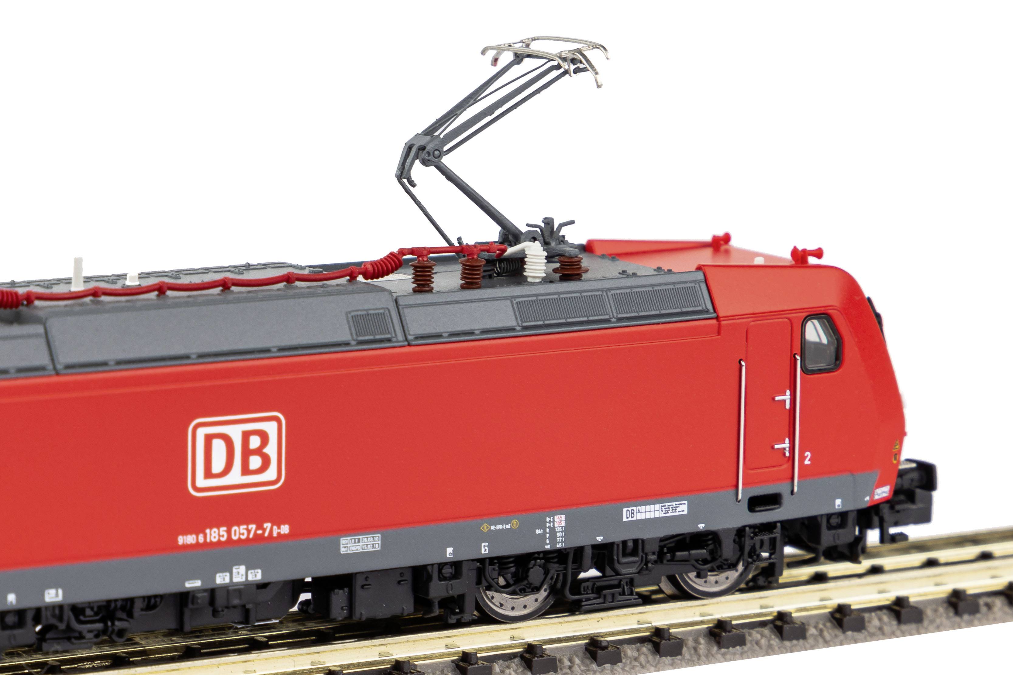 Ein roter Modellzug mit dem Logo der Deutschen Bahn fährt auf Schienen. Der Zug besitzt einen Stromabnehmer auf dem Dach.