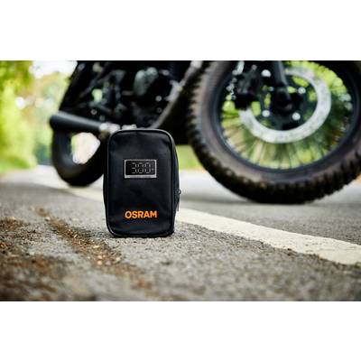 Eine schwarze Tasche mit der Aufschrift 'OSRAM' steht auf einer Straße, im Hintergrund ist ein Teil eines Motorrads zu sehen.