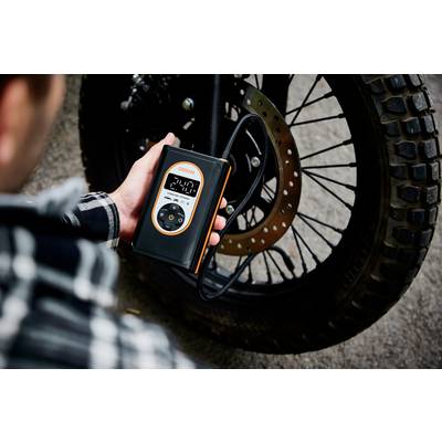 Eine Person prüft mit einem digitalen Gerät den Reifendruck eines Motorrads. Das Display zeigt '2.4' an.
