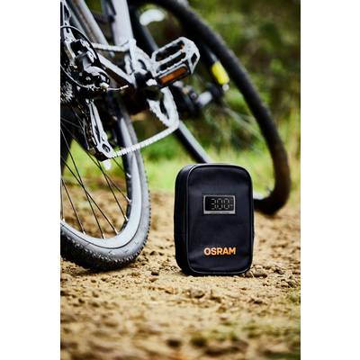 'OSRAM' schwarze Fahrradtasche mit digitaler Anzeige steht auf einem Waldweg neben einem Fahrrad.