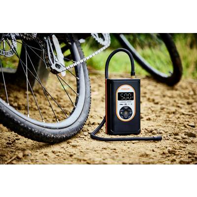 Luftkompressoranhänger auf schlammigem Boden bei Fahrrad. Zeigt 5,0 auf Display, mit Schlauch angeschlossen. Ideal für Fahrradreifenaufpumpen.