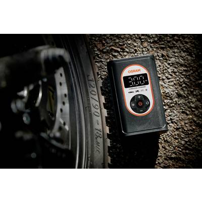 Ein elektronischer Luftdruckmesser zeigt '3.00' neben einem Fahrradreifen auf einer Asphaltstraße an. Das Logo 'OSRAM' ist sichtbar.