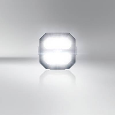 Ein leuchtendes, quadratisches Licht in einem neutralen Raum, das auf einer glatten Fläche reflektiert wird.