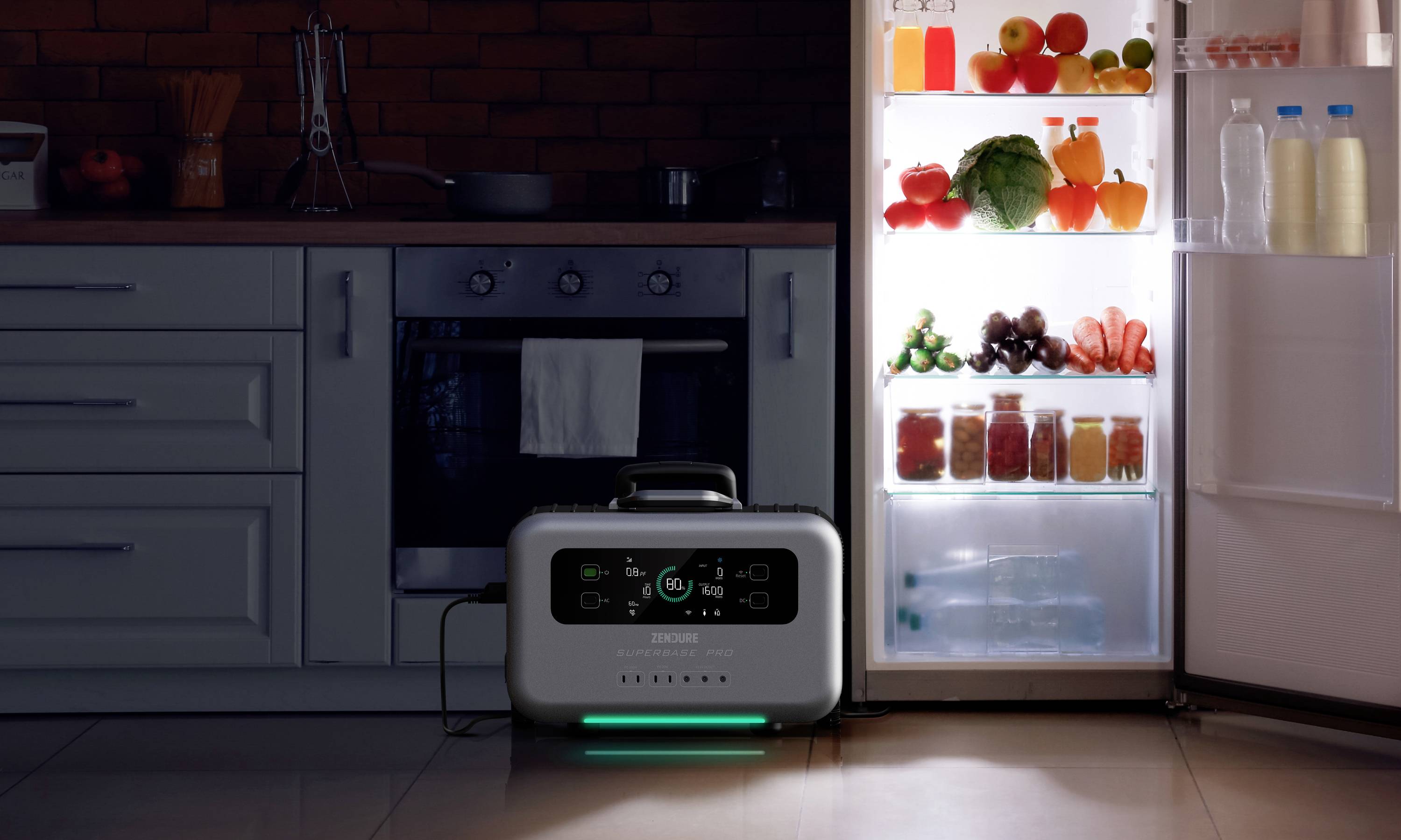 Ein tragbarer Akku steht auf dem Küchenboden. Ein geöffneter Kühlschrank voller Gemüse und Getränke beleuchtet die Szene.