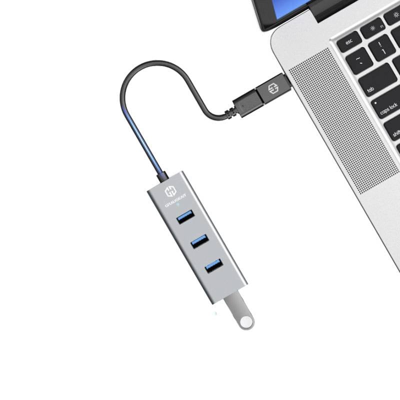 Ein USB-Hub mit drei blauen USB-Anschlüssen ist an einen Laptop angeschlossen.