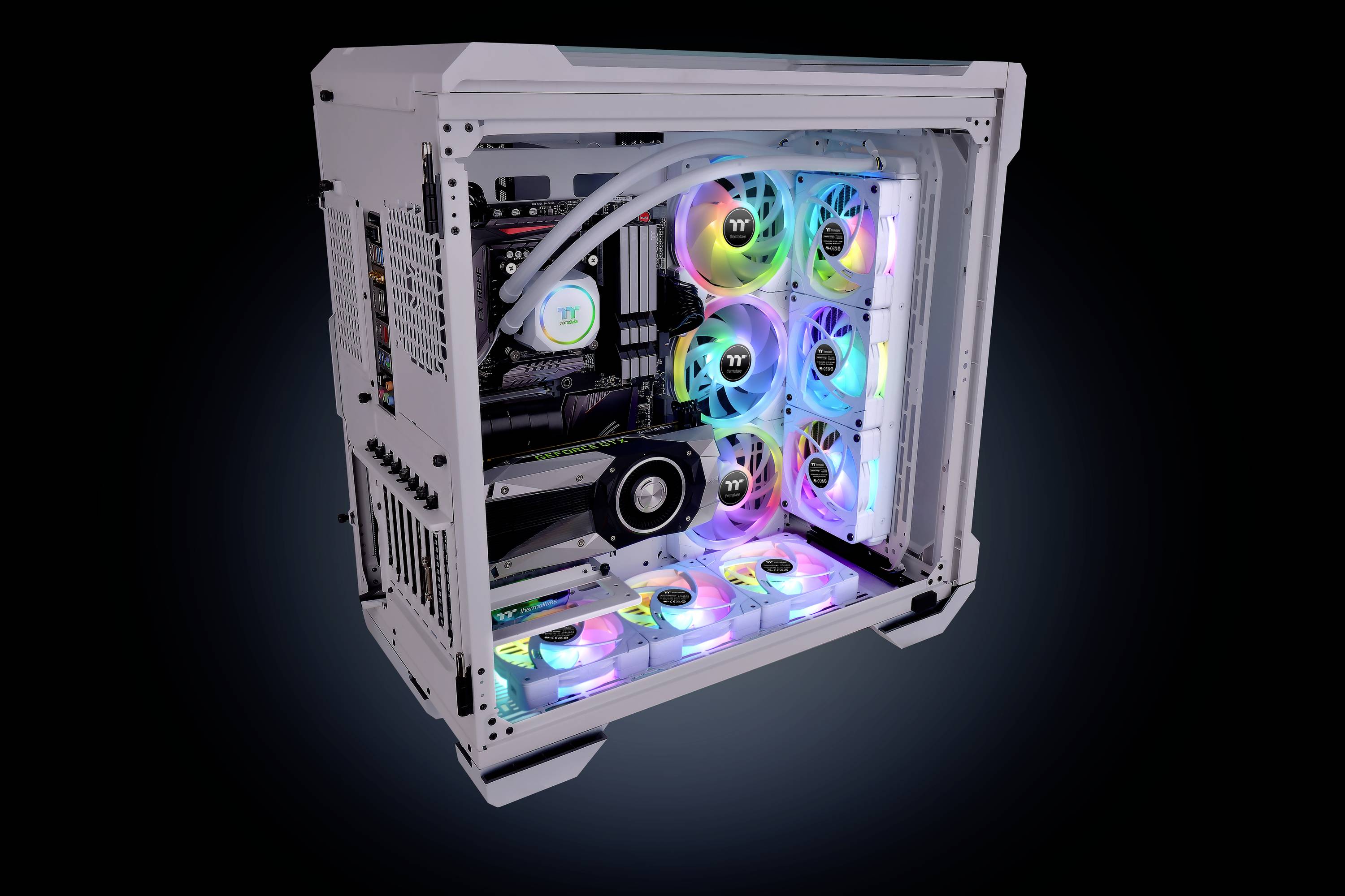 Ein weißer Computergehäuse mit durchsichtiger Seite zeigt RGB-beleuchtete Lüfter und Hardware-Komponenten mit farbigen Lichtern.