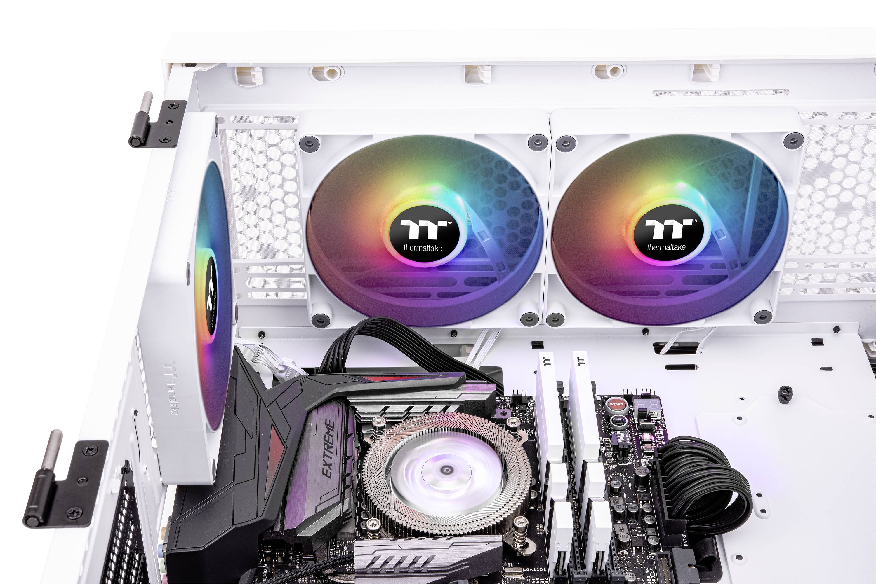 Ein geöffneter Computer mit einem Motherboard und drei RGB-Lüftern, die in verschiedenen Farben leuchten.
