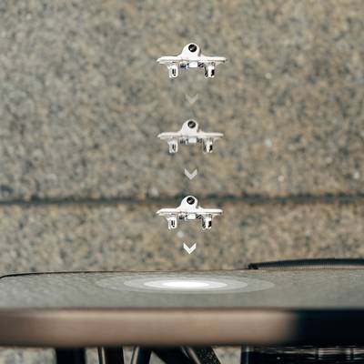 Drohne schwebt über einer Plattform und zeigt den Landevorgang unter freiem Himmel, dargestellt in mehreren aufeinanderfolgenden Positionen.