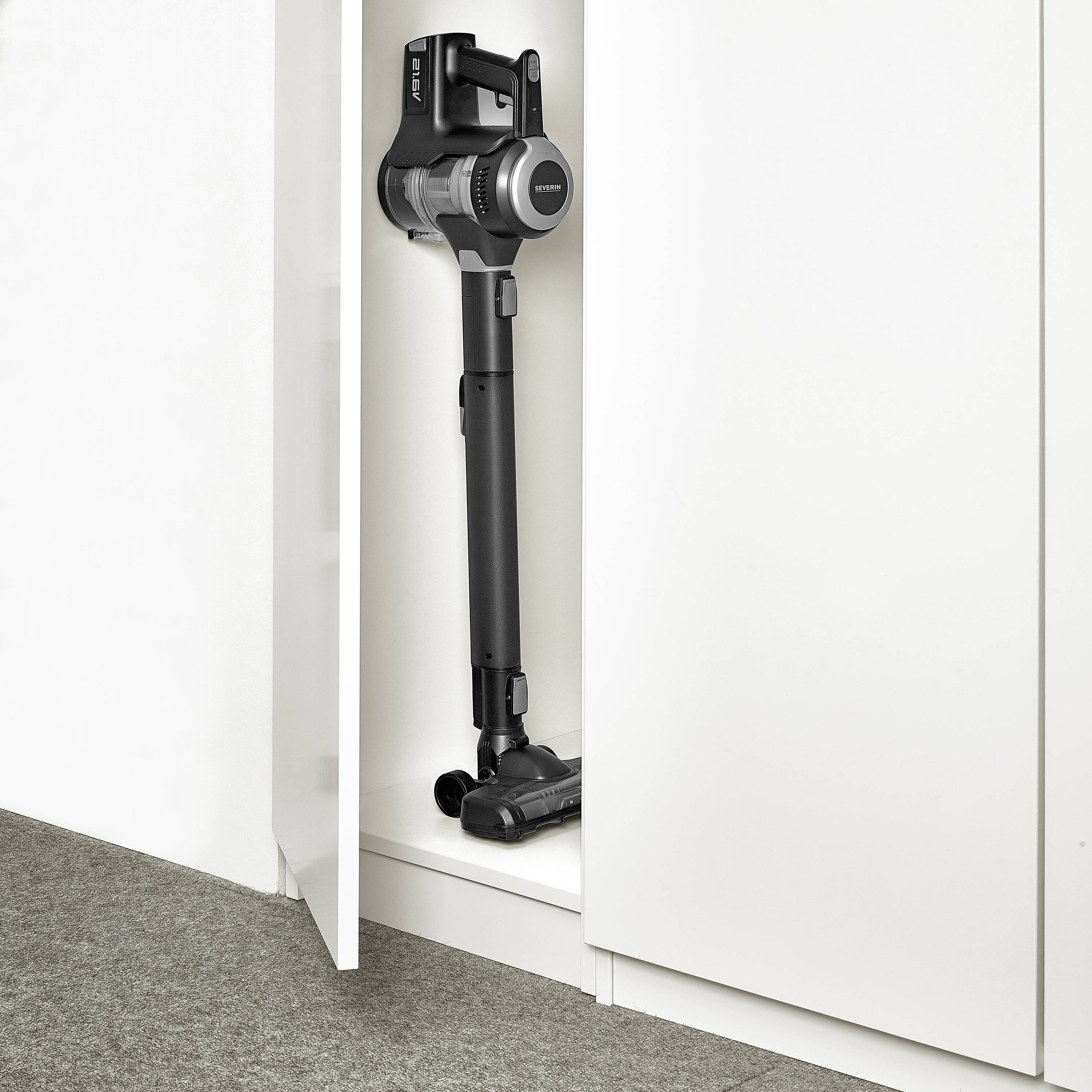 Ein schwarzer kabelloser Staubsauger ist in einem schmalen weißen Schrank verstaut und zeigt seine platzsparende Aufbewahrungslösung.