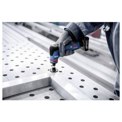 Ein Arbeiter mit Handschuhen verwendet ein schnurloses Elektrowerkzeug von Bosch, um ein Metallpanel auf einer durchbrochenen Werkbank in einer Werkstatt zu befestigen.