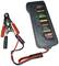 Batterietester mit angeschlossenen Klemmen zeigt Ladestatus an. LEDs für 'Defekt', 'Gut', 'Voll', 'Halbvoll', 'Schwach' und 'Batterie OK'.