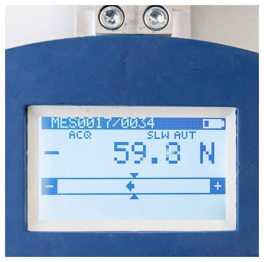 Nahaufnahme einer Geräteanzeige mit der Messwertangabe „59,8 N", „MES0017/0054" und „SLW AUT" auf dem Bildschirm.