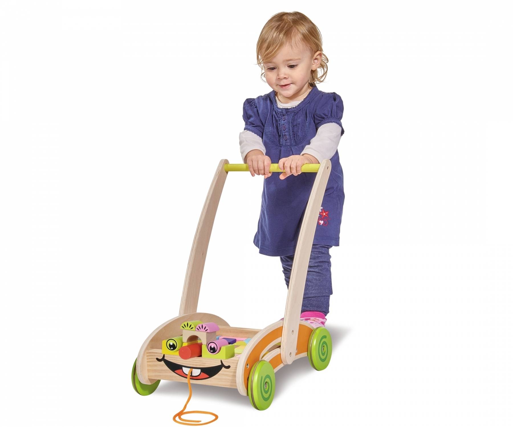 Kind steckt Spielzeugwagen mit bunten Details, lächelt.