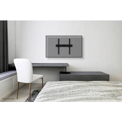 Ein flaches Fernseher-Wandmontagesystem in einem minimalistisch eingerichteten Schlafzimmer, der Fernseher fehlt noch.