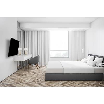 Modernes Schlafzimmer mit einem großen Bett, einem Schreibtisch und einem Stuhl. Ein Fenster lässt viel natürliches Licht herein.
