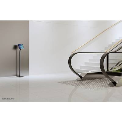 Ein digitaler Infostand mit Tablet steht neben einer modernen Treppe in einem hellen, minimalistischen Raum.