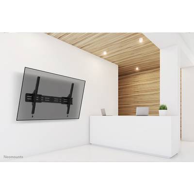 Empfangsbereich mit weißem Tresen, Laptop, Topfpflanze und großer, schräg montierter Flachbildschirm an der Wand links. Moderne Ästhetik.