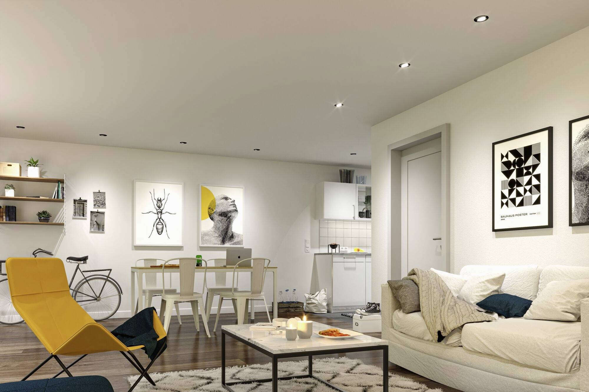 Ein modernes Wohnzimmer mit offener Küche. Auf der linken Seite stehen ein Fahrrad und Regale. Rechts eine gemütliche Sofalandschaft und ein Couchtisch mit Kerzen. Wandbilder schmücken den Raum.