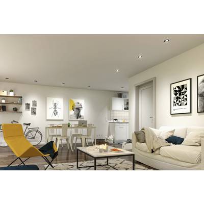 Modernes Wohnzimmer mit offener Küche. Gemütliches Sofa, Sessel, Couchtisch mit Kerzen. Stilvolle Kunstwerke und Fahrrad an der Wand.