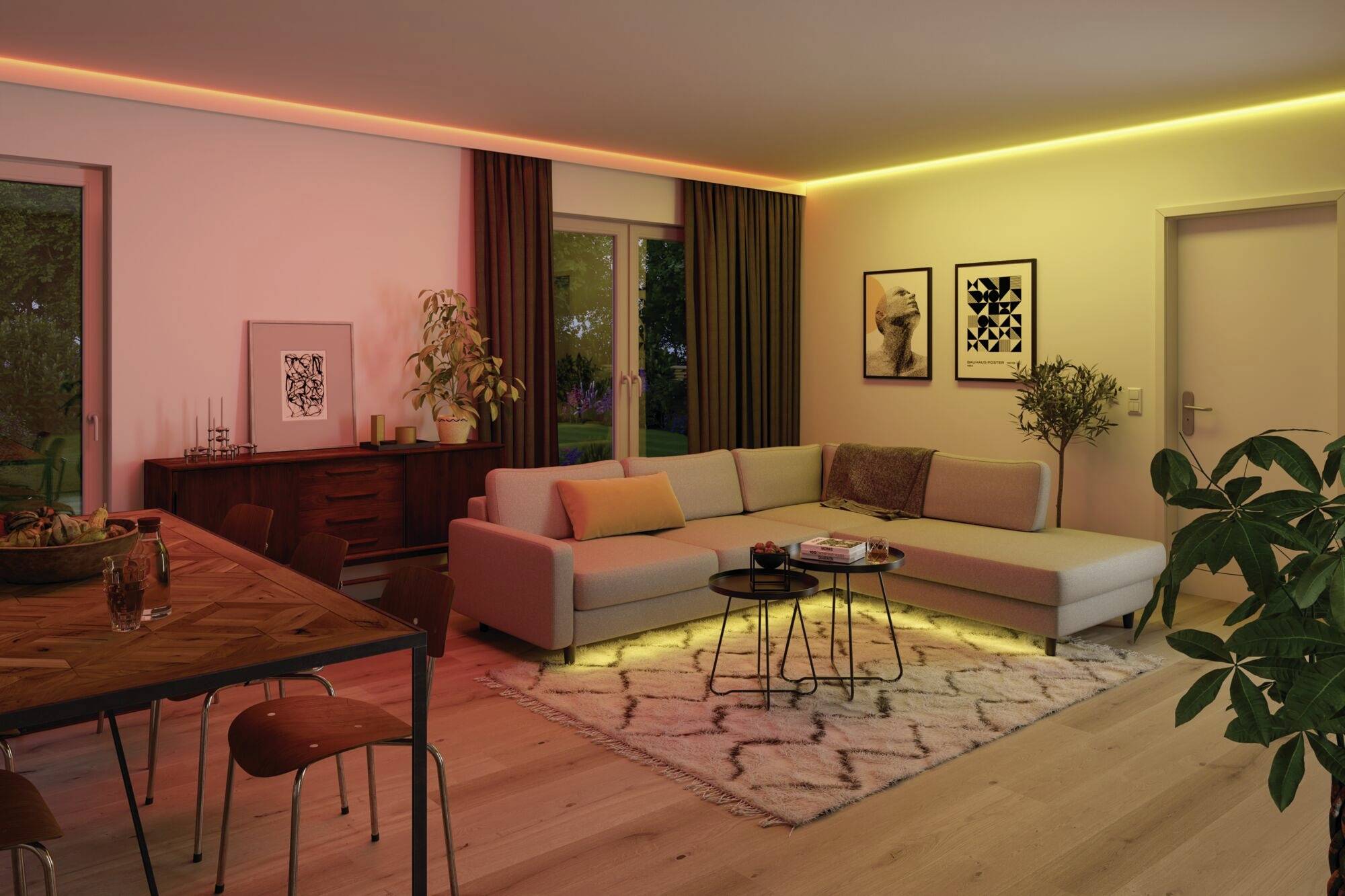 Gemütliches Wohnzimmer mit L-förmigem Sofa, Teppich und Wandbildern. Warme Beleuchtung und Pflanzen verleihen eine einladende Atmosphäre.