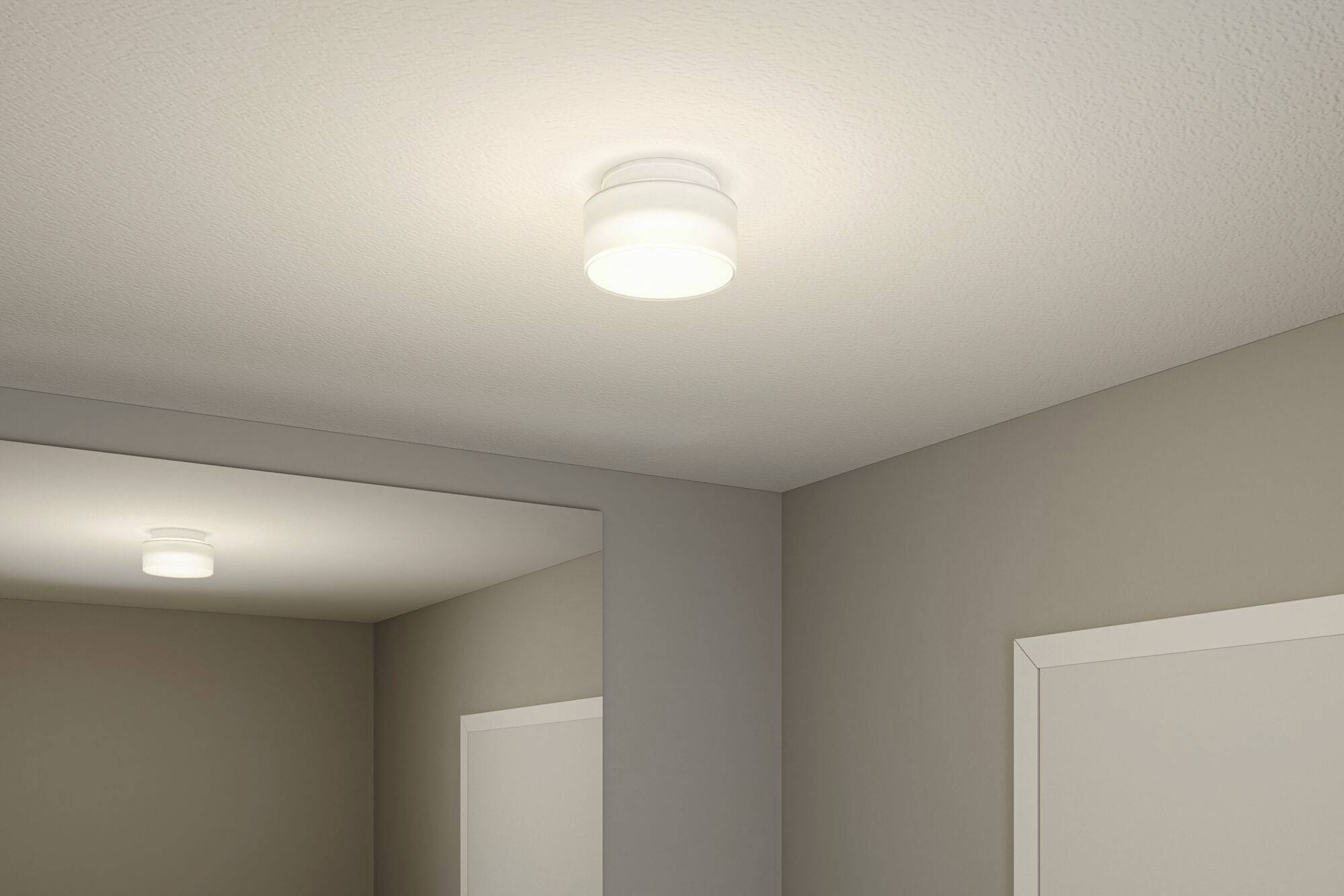 Deckenleuchte in einem Raum, die gleichmäßig Licht spendet. Wände sind neutralfarben, Türen in Weiß gehalten.