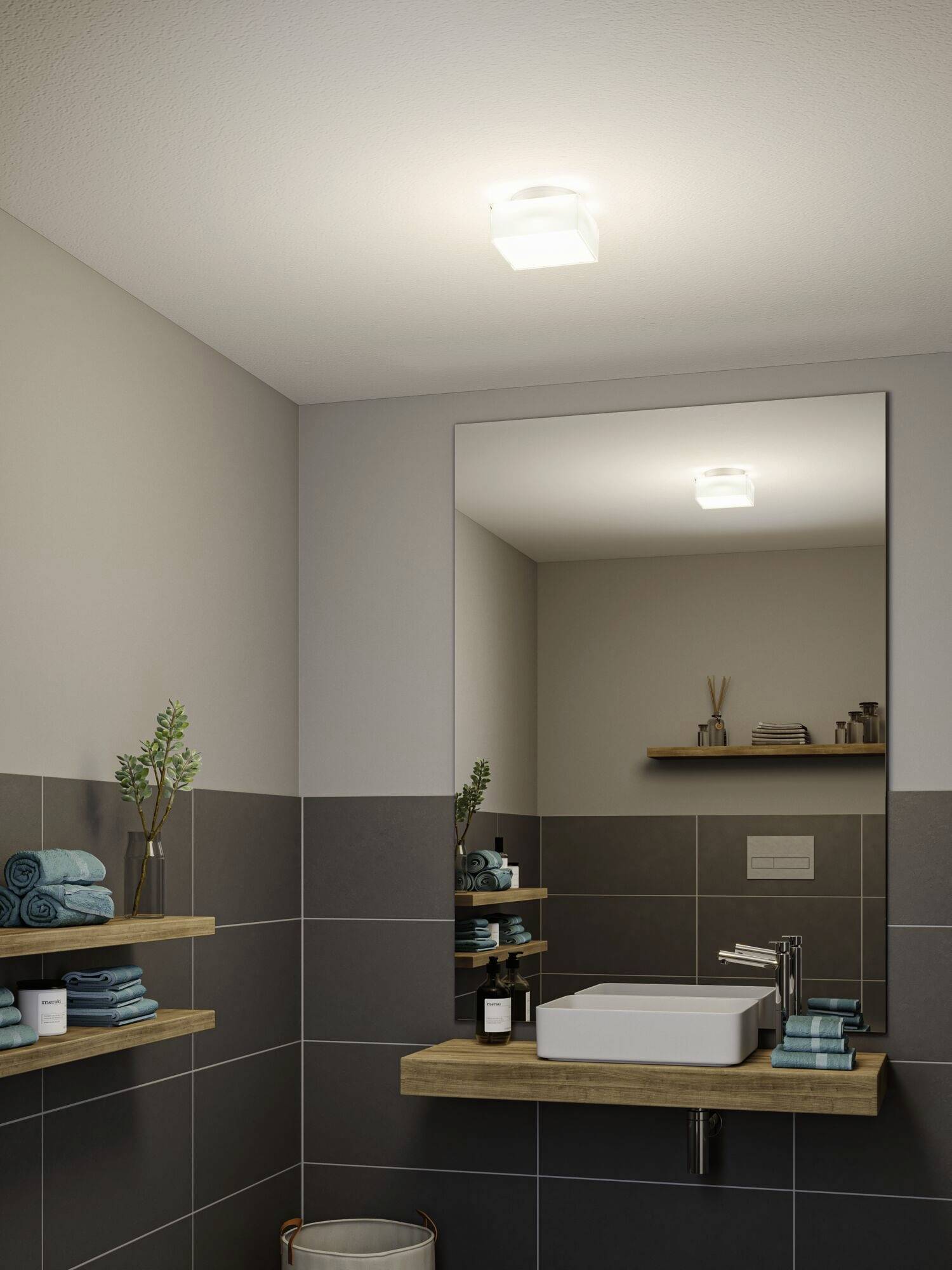 Modernes Badezimmer mit einem rechteckigen Spiegel über einem Waschbecken. Regale mit Handtüchern und Dekorationsartikeln an den Wänden.