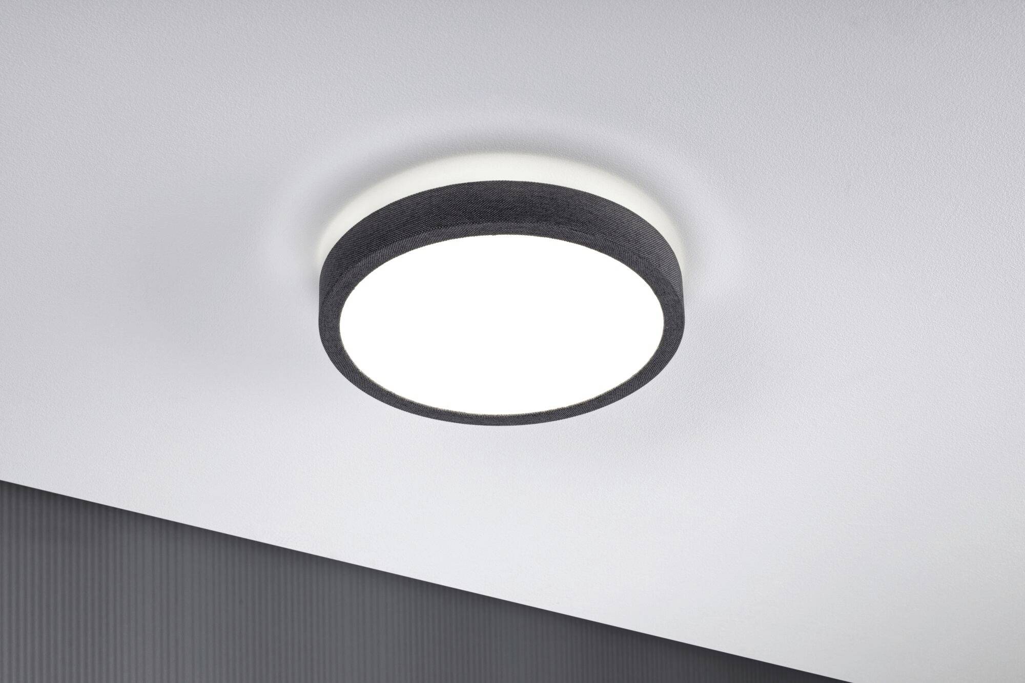 Deckenleuchte mit schwarzem Rand und weißem Licht, an einer grauen Decke montiert. Minimalistisches Design.