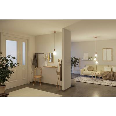 Wohnzimmer mit beiger Couch, Holztisch und dekorativen Lampen. Eine Pflanze und ein Spiegel befinden sich im Eingangsbereich.