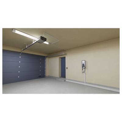 Ein sauberes Garageninneres mit einem geschlossenen blauen Garagentor und einer Elektrofahrzeug-Ladestation, die an der rechten Wand montiert ist.