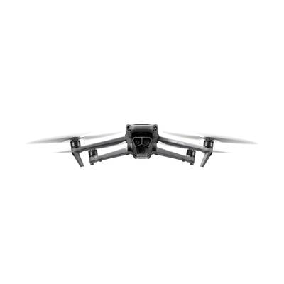 Eine graue Drohne mit vier Rotoren fliegt frontal auf weißem Hintergrund.